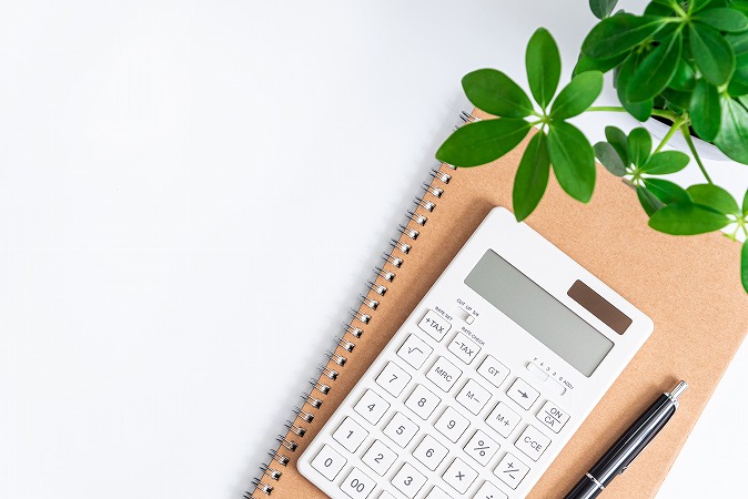 ノートの上に電卓と黒ペン